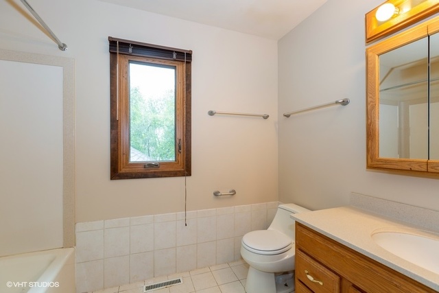 3017 Springbrook Road Crystal Lake, IL 60012 - Photo 15 of 20 a bathroom with a granite countertop toilet a sink and a mirror