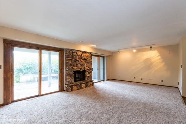 3017 Springbrook Road Crystal Lake, IL 60012 - Photo 8 of 20 a view of an empty room with a fireplace and a large window