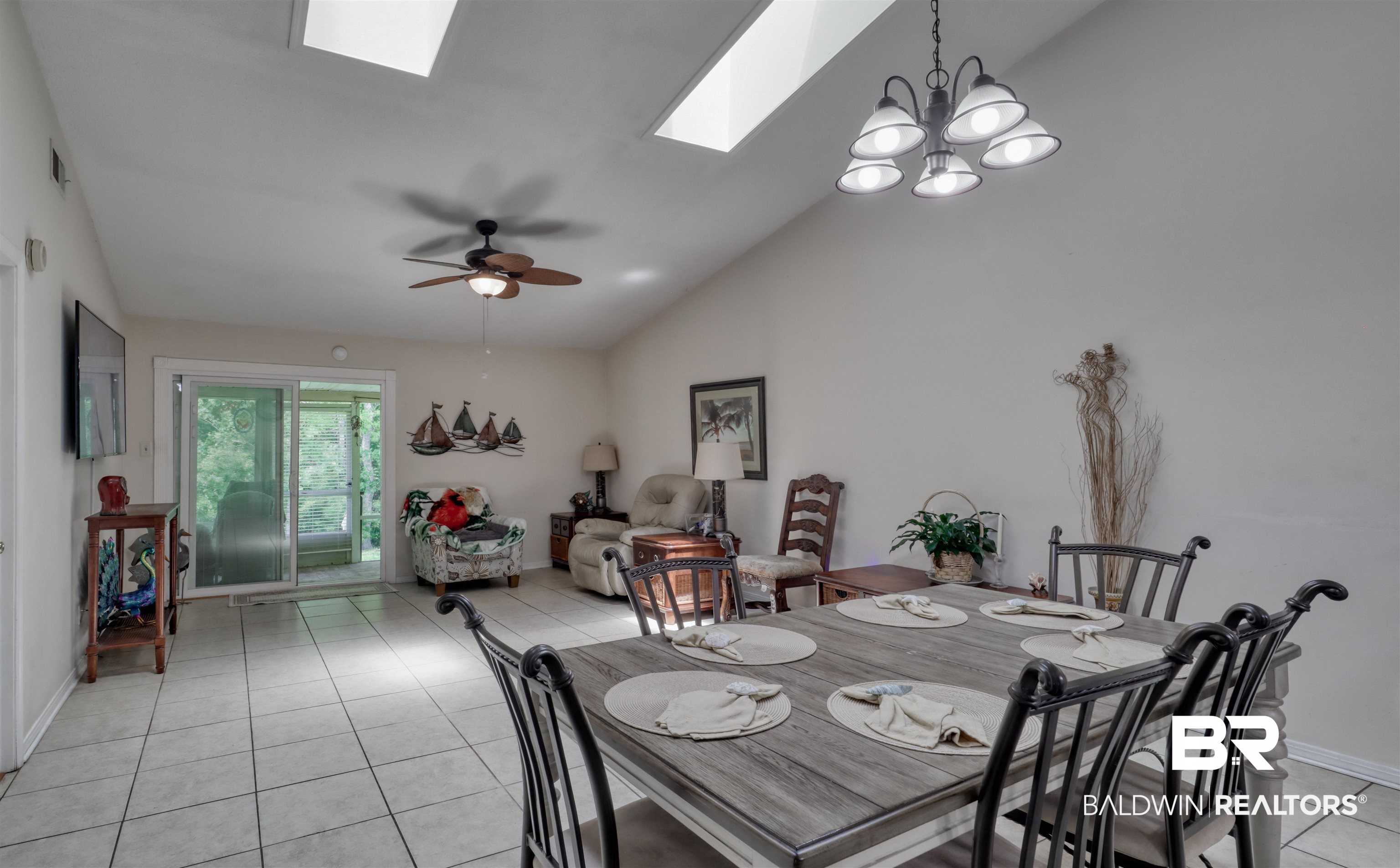 3200 Loop Road, Unit 61 Orange Beach, AL 36561 - Photo 5 of 32 Dining space featuring a skylight, lofted ceiling, light tile patterned floors, a chandelier, and a ceiling fan