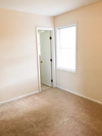 an empty room with windows and closet