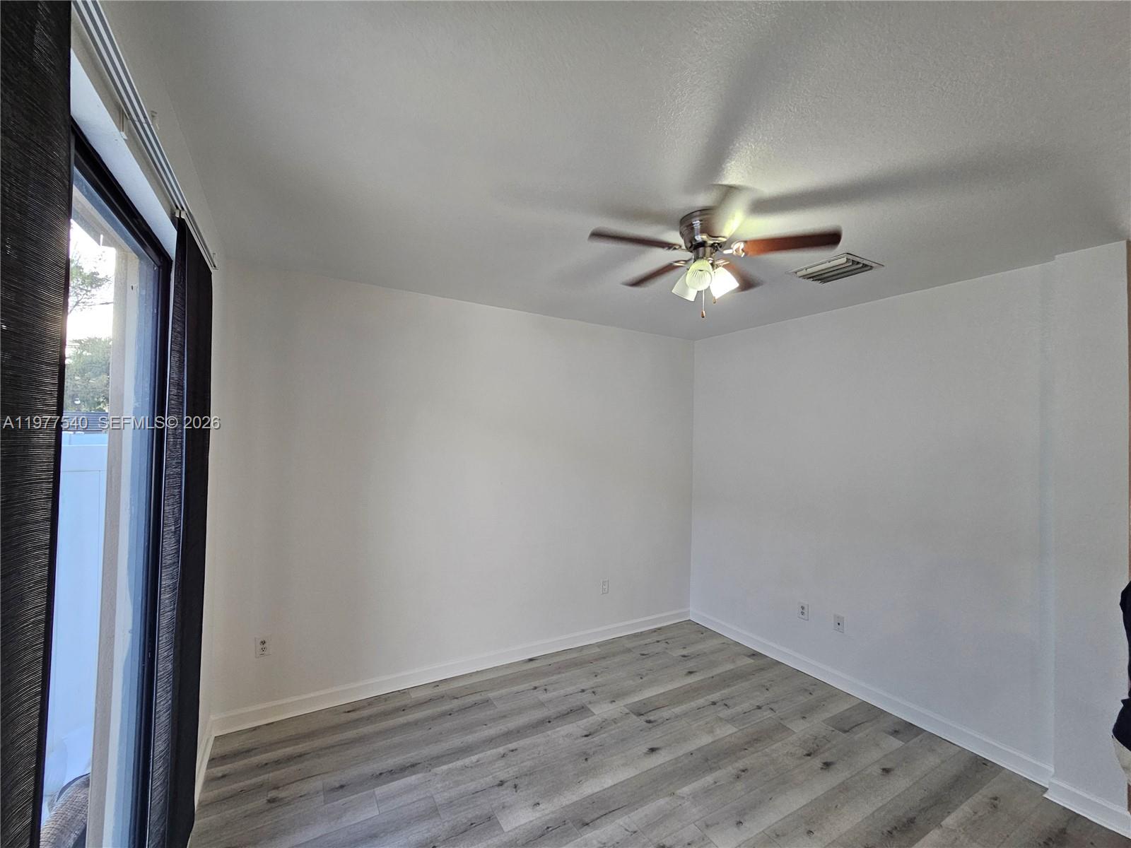 3370 West 90th Street, Unit A Hialeah, FL 33018 - Photo 12 of 40 wooden floor in an empty room with a window