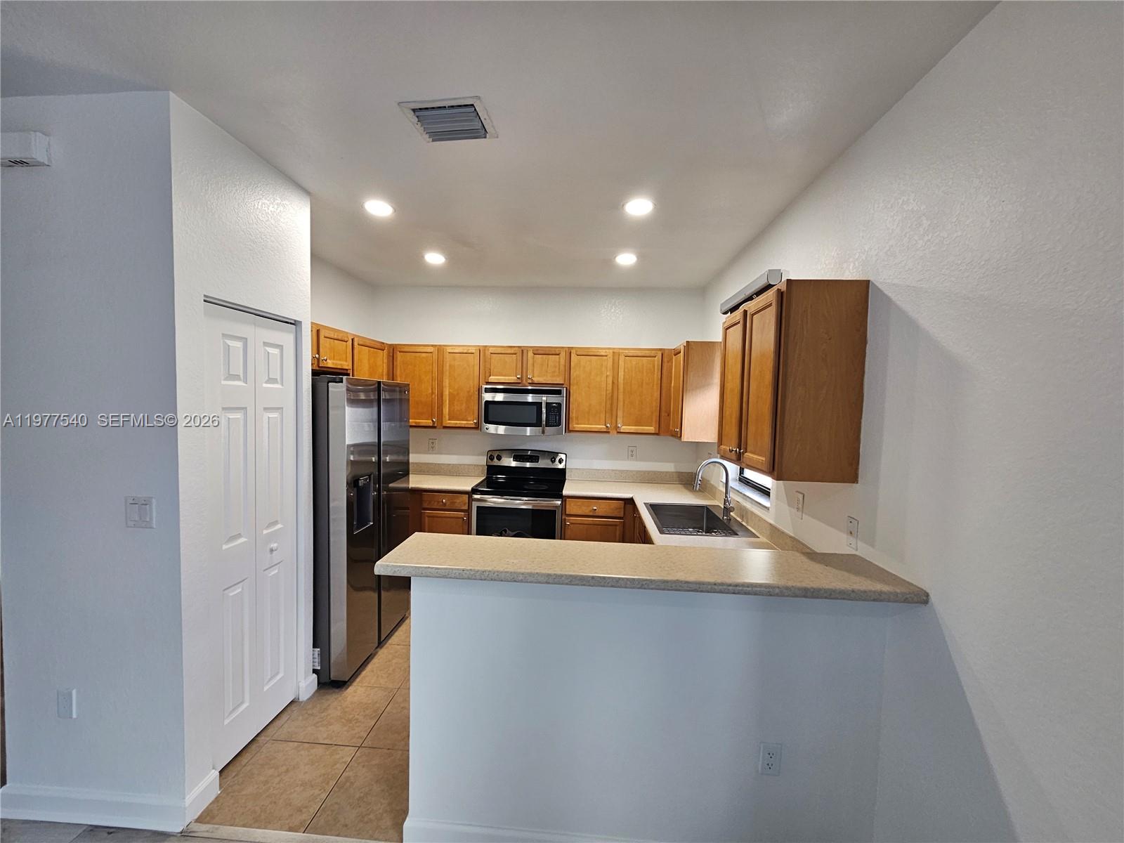 3370 West 90th Street, Unit A Hialeah, FL 33018 - Photo 13 of 40 a kitchen with stainless steel appliances a refrigerator sink and stove