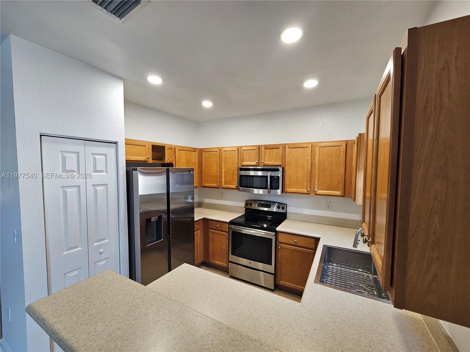 3370 West 90th Street, Unit A Hialeah, FL 33018 - Photo 14 of 40 a kitchen with stainless steel appliances granite countertop a refrigerator a stove a sink and a microwave