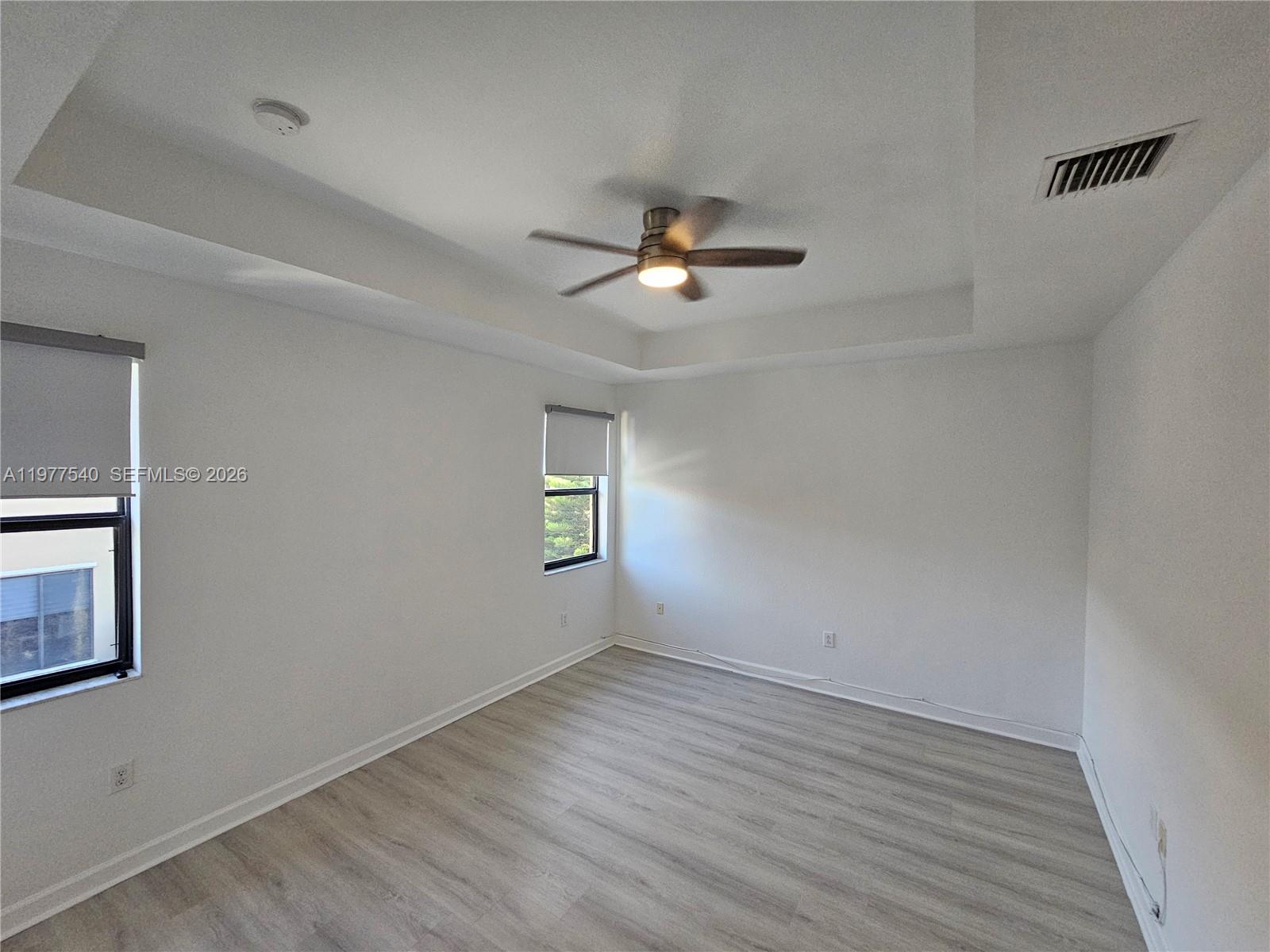 3370 West 90th Street, Unit A Hialeah, FL 33018 - Photo 19 of 40 an empty room with wooden floor chandelier fan and windows
