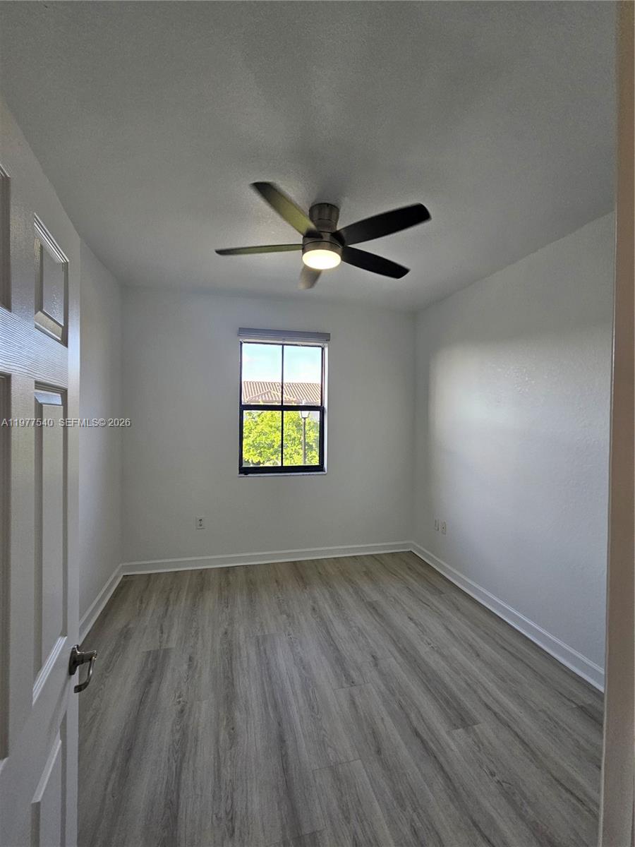 3370 West 90th Street, Unit A Hialeah, FL 33018 - Photo 31 of 40 an empty room with wooden floor and windows