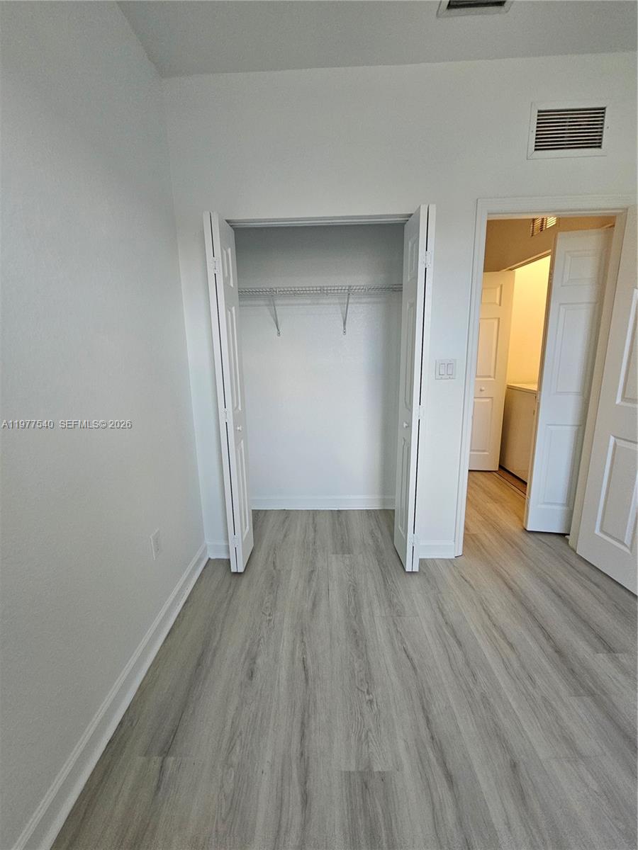 3370 West 90th Street, Unit A Hialeah, FL 33018 - Photo 32 of 40 an empty room with wooden floor and closet
