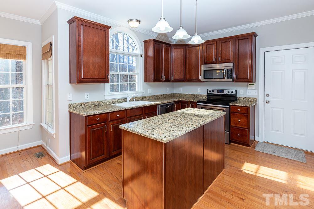 5001 Perception Lane Raleigh, NC 27613 - Photo 8 of 28 a kitchen with stainless steel appliances granite countertop wooden cabinets a stove top oven a sink and dishwasher