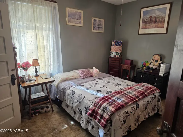 a bedroom with a bed table and a window