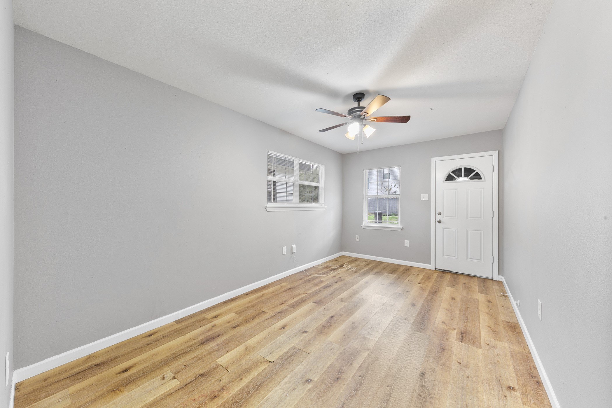 2106 Hadley Street, Unit 2106 Houston, TX 77004 - Photo 2 of 11 an empty room with windows and a ceiling fan