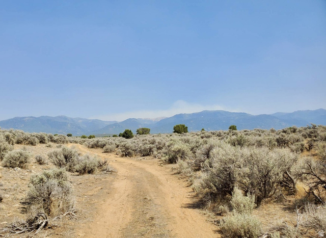 Undisclosed Address Spring City, UT 84662 - Photo 14 of 19 Expansive natural landscape with a clear sky, a winding dirt path, and distant mountains