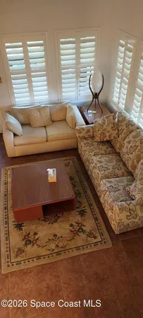 a living room with a couch a window and a dining table