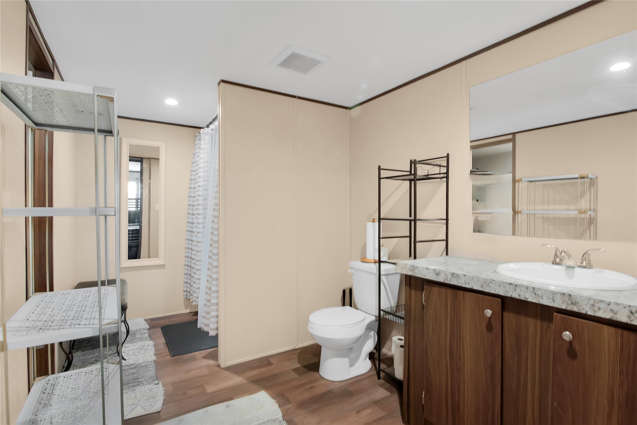 1007 Keswick Road Wilmer, TX 75172 - Photo 10 of 16 a spacious bathroom with a granite countertop sink toilet a mirror and shower