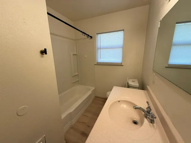 a bathroom with a tub sink and mirror