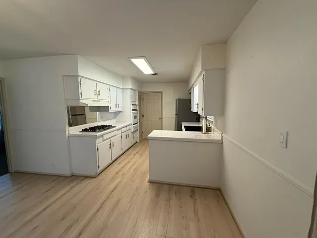 a kitchen with white cabinets and white appliances