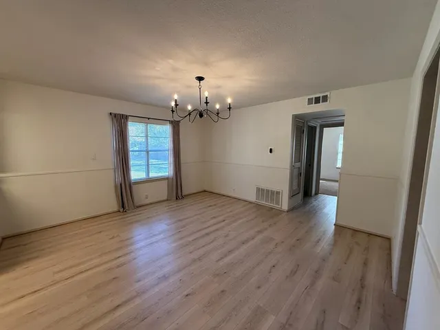 a view of a livingroom with wooden floor and chandelier