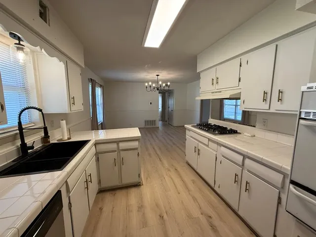 a kitchen with a sink stove and cabinets