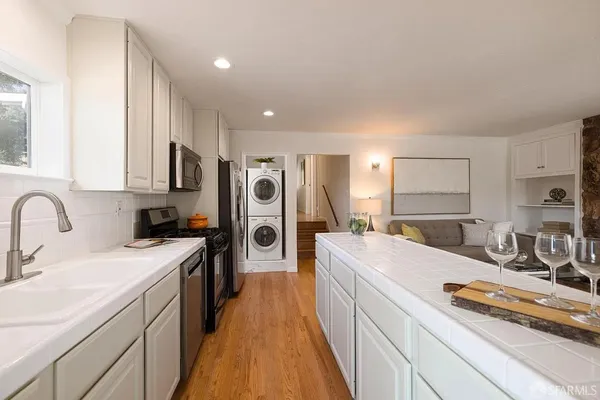 a large kitchen with stainless steel appliances granite countertop a sink stove and refrigerator