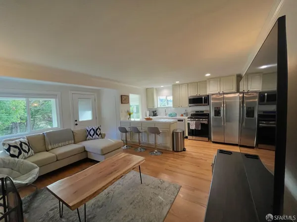 a living room with furniture and a kitchen view