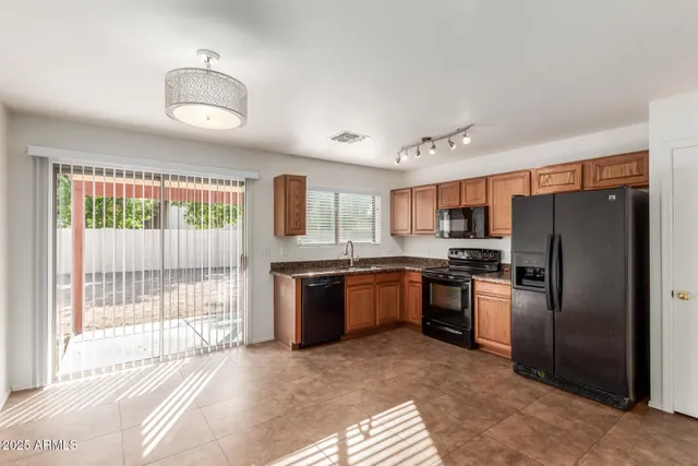 a kitchen with stainless steel appliances granite countertop a refrigerator and a stove top oven