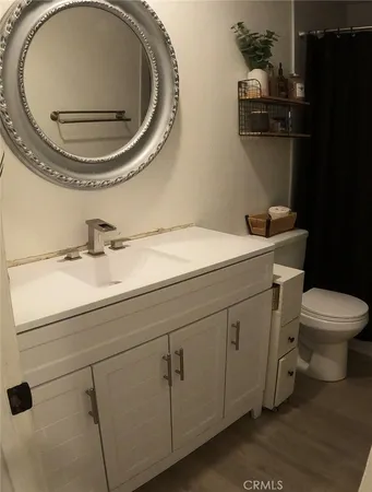 a bathroom with a sink a toilet and a mirror
