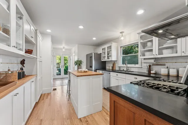 a kitchen with stainless steel appliances a sink stove and cabinets