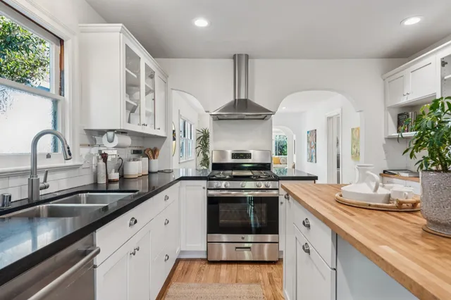a kitchen with stainless steel appliances a sink stove and cabinets