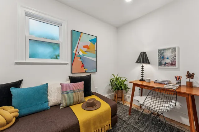 a bedroom with a large bed and a painting on the wall