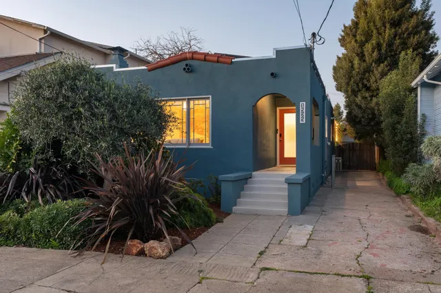 a patio with table and chairs and potted plants