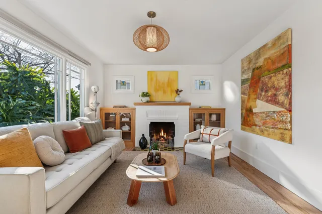 a living room with furniture a fireplace and a large window