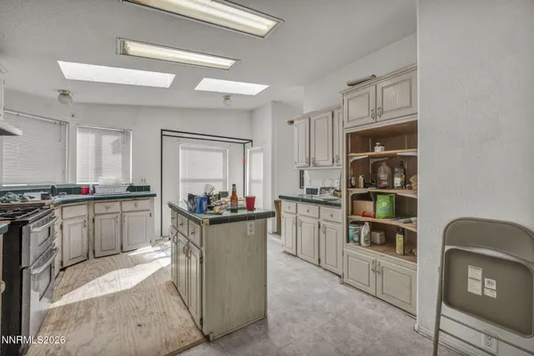 a kitchen with kitchen island a refrigerator stove and sink