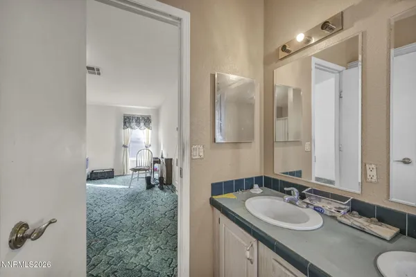 a bathroom with a granite countertop toilet a sink and a mirror