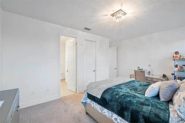 a bedroom with a bed wooden floor and window