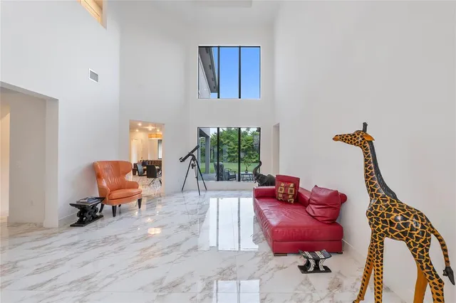 a kitchen with a stove a sink a counter top space and living room view