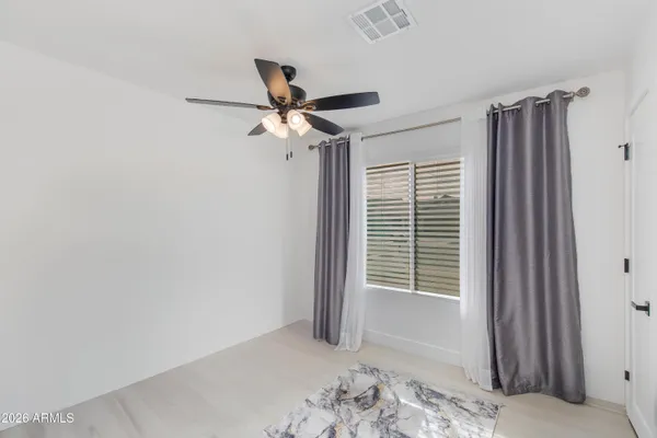 a view of a bedroom with a ceiling fan and a window