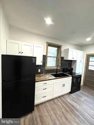 a kitchen with granite countertop a refrigerator and a sink