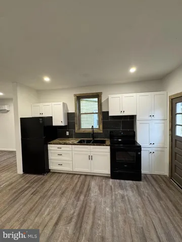a kitchen with stainless steel appliances kitchen island granite countertop a refrigerator and a stove top oven