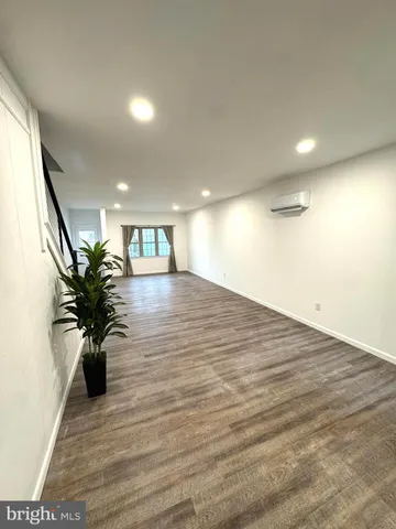 a view of a room with wooden floor and a potted plant