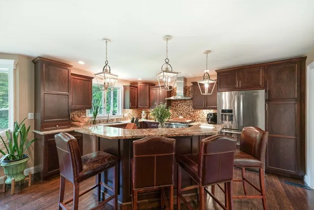 a view of kitchen with refrigerator stove dining table and chairs