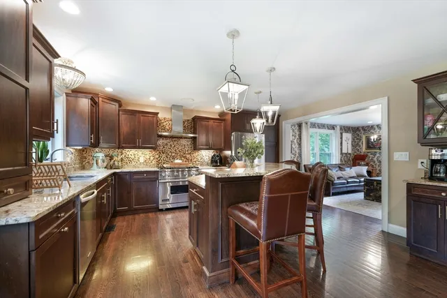 a kitchen with a dining table chairs stainless steel appliances and cabinets