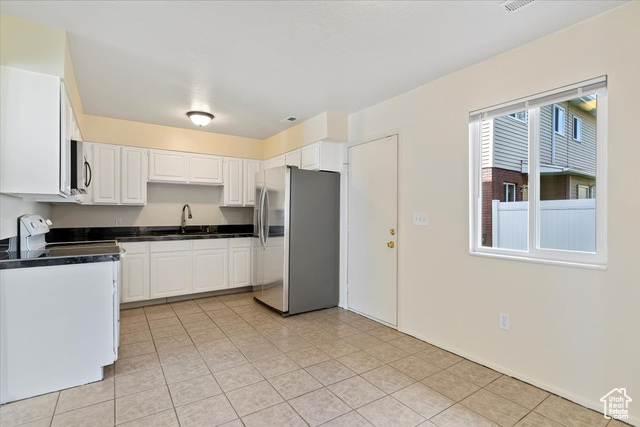 947 Canyon Road South, Unit 15 Ogden, UT 84404 - Photo 8 of 22 Kitchen with white cabinets, appliances with stainless steel finishes, and light tile patterned floors