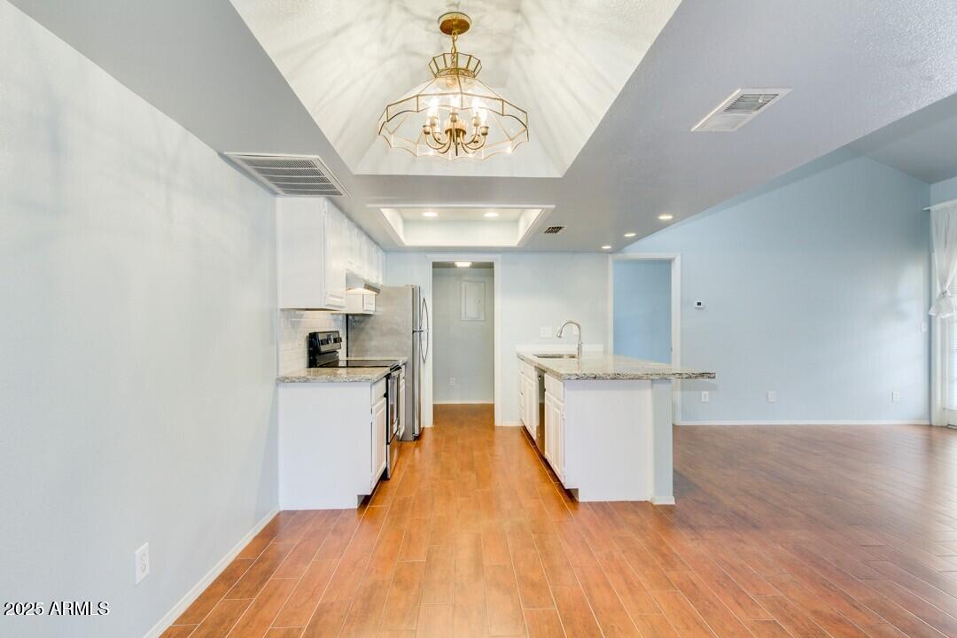 6900 East Gold Dust Avenue, Unit 149 Paradise Valley, AZ 85253 - Photo 11 of 34 a large kitchen with a lot of counter space and a wooden floor