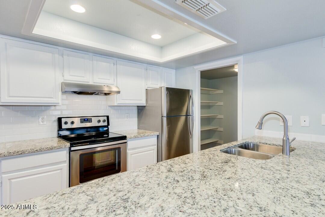 6900 East Gold Dust Avenue, Unit 149 Paradise Valley, AZ 85253 - Photo 14 of 34 a kitchen with kitchen island stainless steel appliances a sink stove and refrigerator
