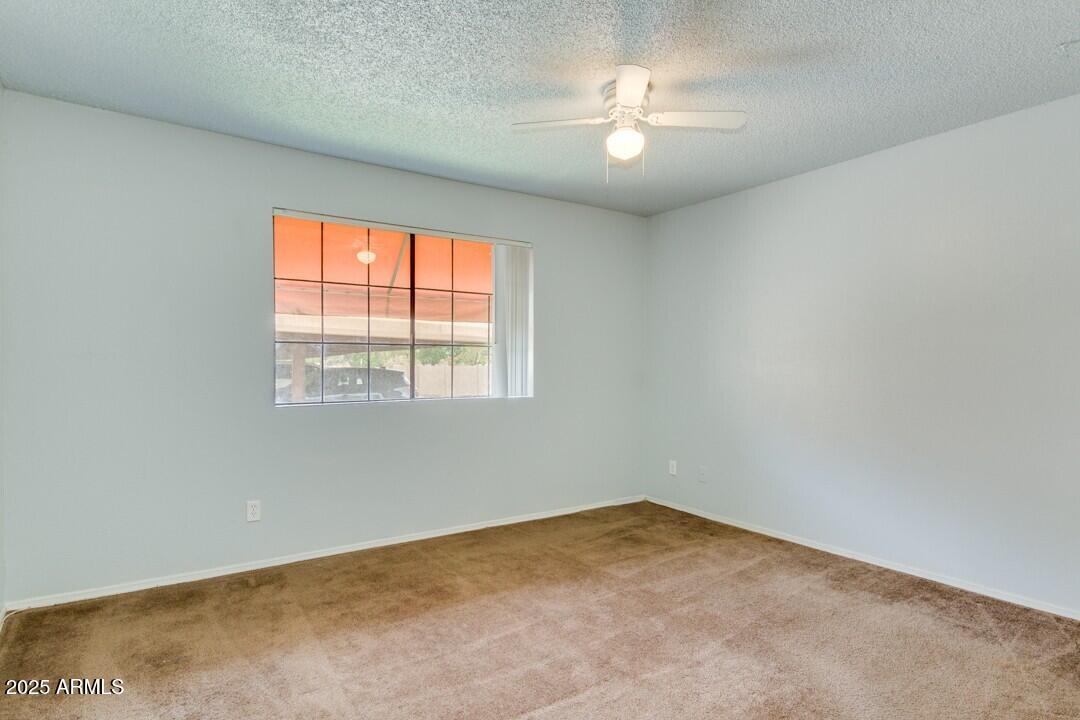 6900 East Gold Dust Avenue, Unit 149 Paradise Valley, AZ 85253 - Photo 27 of 34 an empty room with a chandelier fan and windows