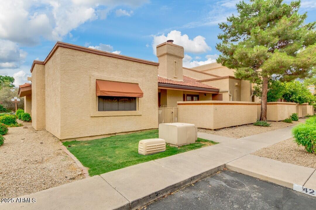 6900 East Gold Dust Avenue, Unit 149 Paradise Valley, AZ 85253 - Photo 4 of 34 a front view of a house with a yard and garage