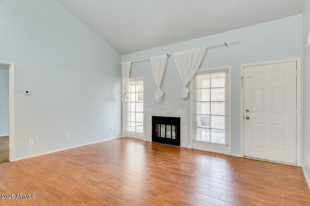 6900 East Gold Dust Avenue, Unit 149 Paradise Valley, AZ 85253 - Photo 10 of 34 an empty room with wooden floor fireplace and windows