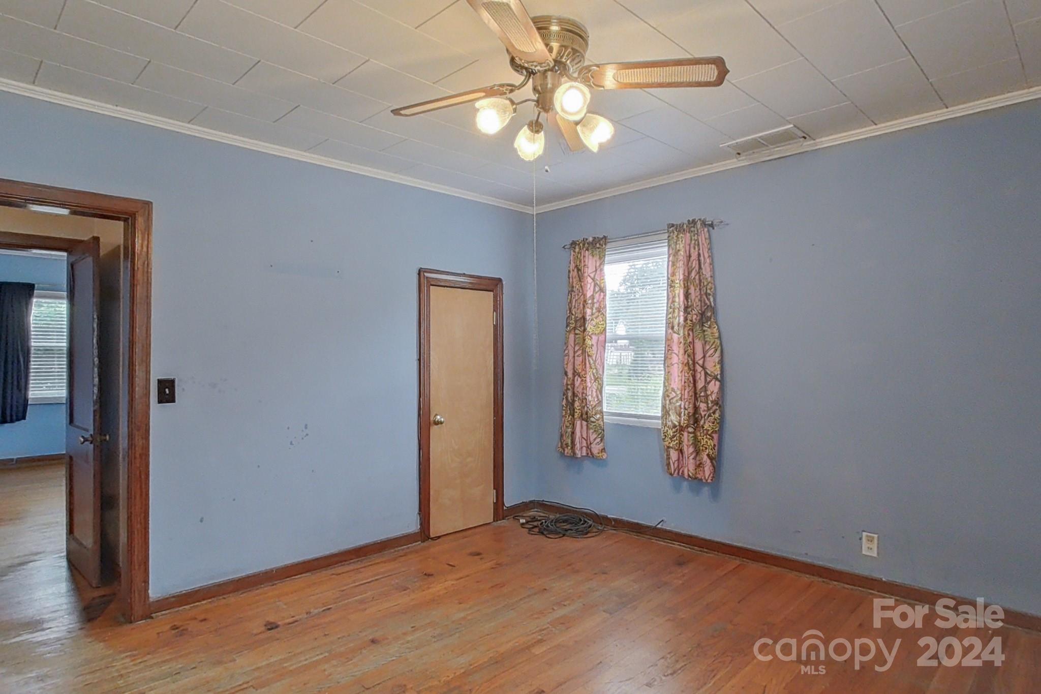 700 South Myrtle School Road Gastonia, NC 28052 - Photo 19 of 40 an empty room with wooden floor and chandelier fan