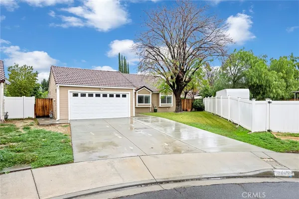 a view of a white house with a yard and garage