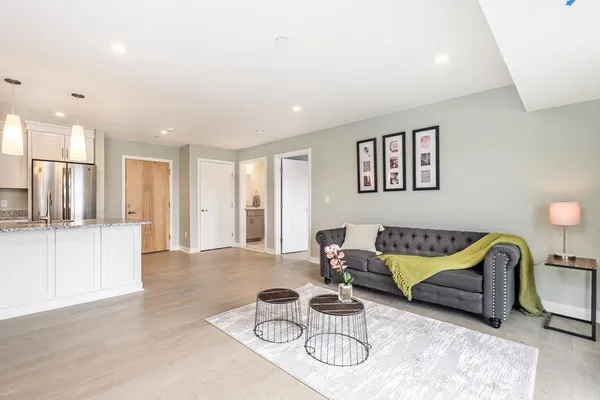 a living room with furniture and a view of kitchen