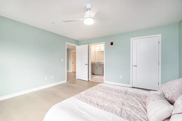 a bedroom with a large bed and a chandelier fan