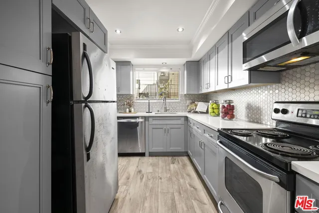 a kitchen with a sink stainless steel appliances and window